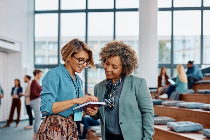 happy-female-entrepreneurs-using-cell-phone-after-2023-08-15-21-18-02-utc